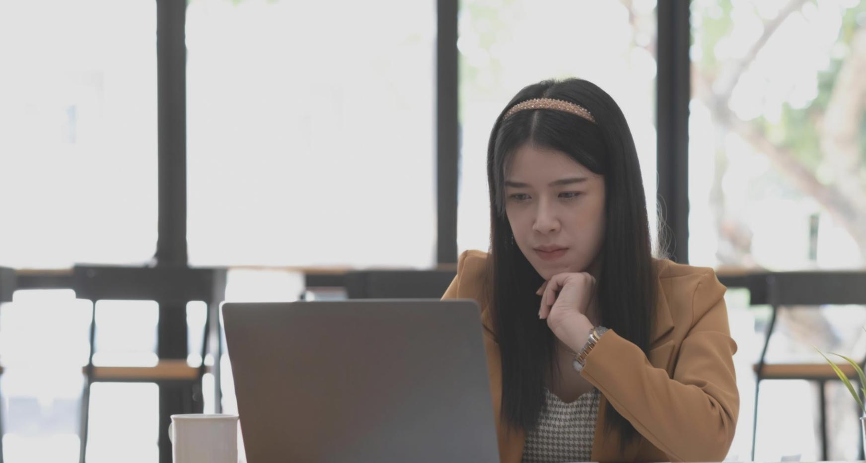 Person reviewing financial statements with laptop